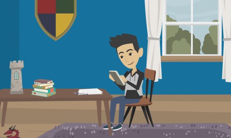 A teen boy sits in his room at his desk. He is holding a notebook and writing on it. He has a happy expression. 