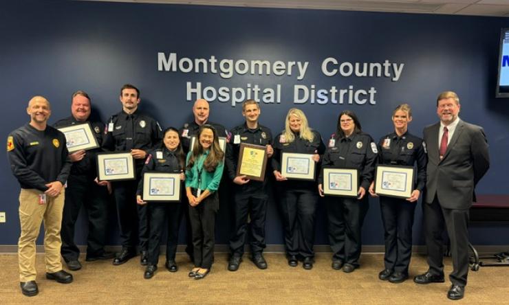 group of people standing together, holding awards and smiling