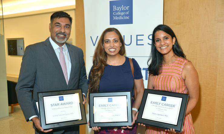 Three people displaying their awards for excellence in patient care.