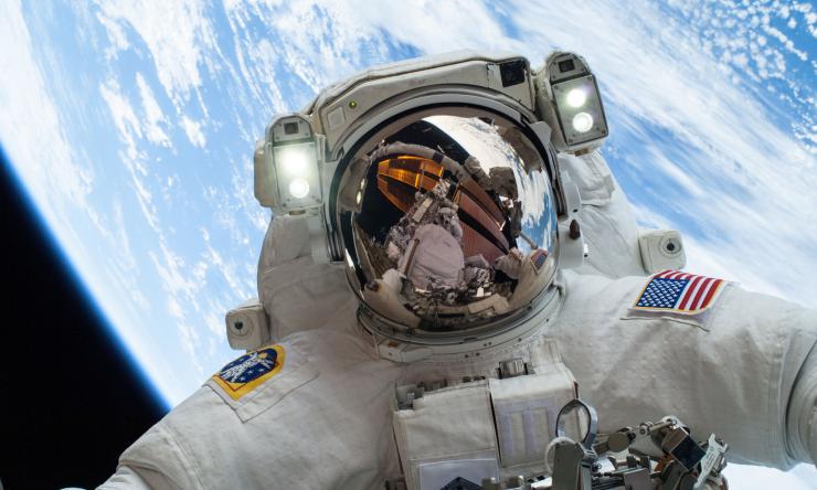 Fellow spacewalker Rick Mastracchio appears in the reflection of Astronaut's Mike Hopkins' helmet.