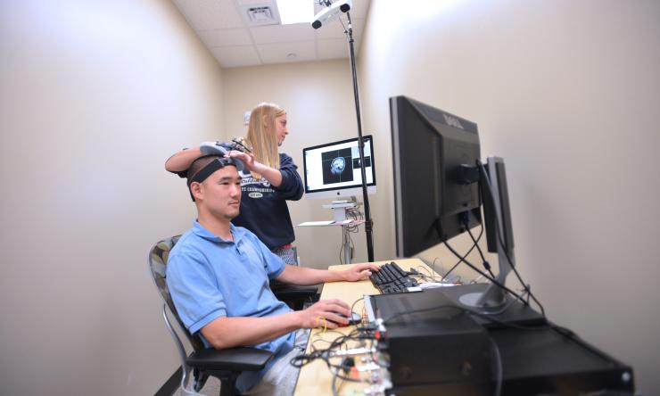 Woman scans patient (wide shot)