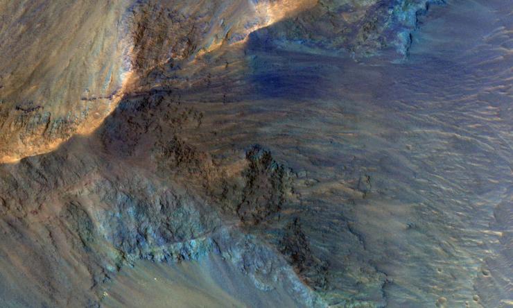 This image captures some of the geologic diversity of Mars. There are hills of ancient terrains on the floor of Juventae Chasma, surrounded by younger sediments, including dark sand sheets and dunes that are likely active today.